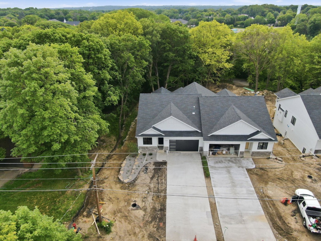 Aerial view of a twin home at Excelsior Woods on its wooded lot